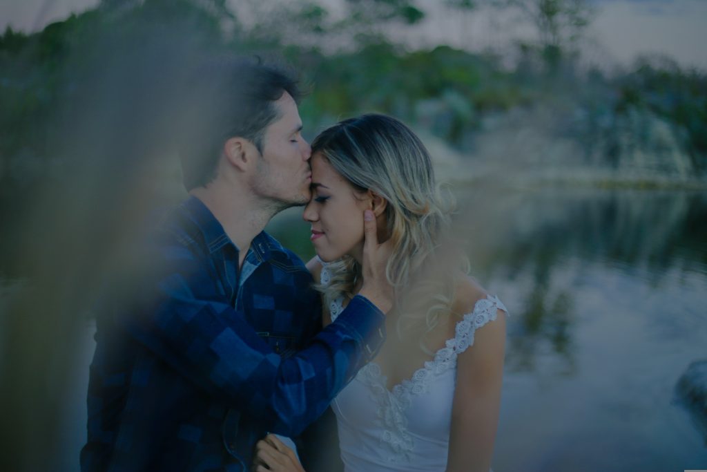 Mann küsst die Frau auf die Stirn.