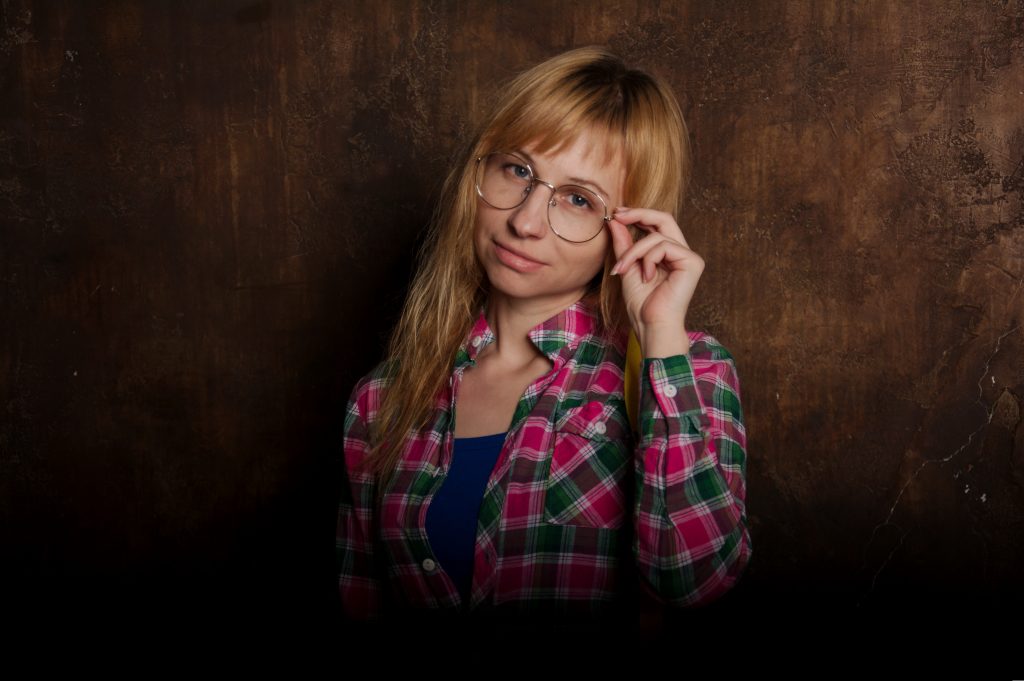 Frau mit Brille schaut fragend.